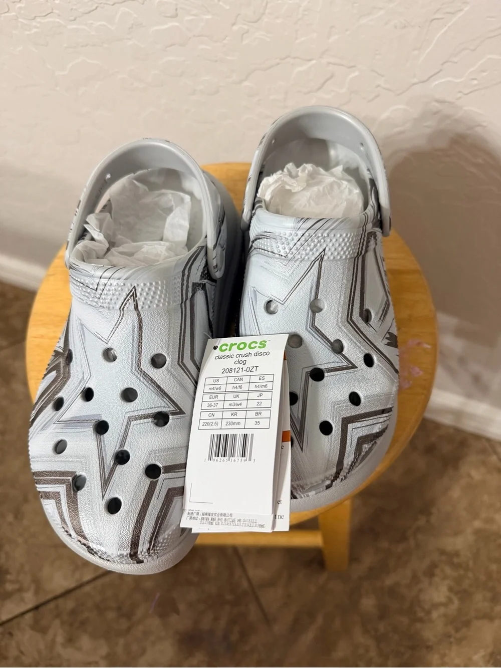 white and gray Crocs with black star and zigzag graphic size W6